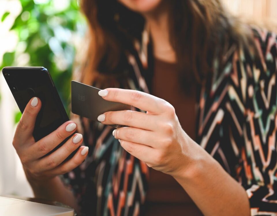 close up of brunette lady tapping an NFC business card on a mobile phone