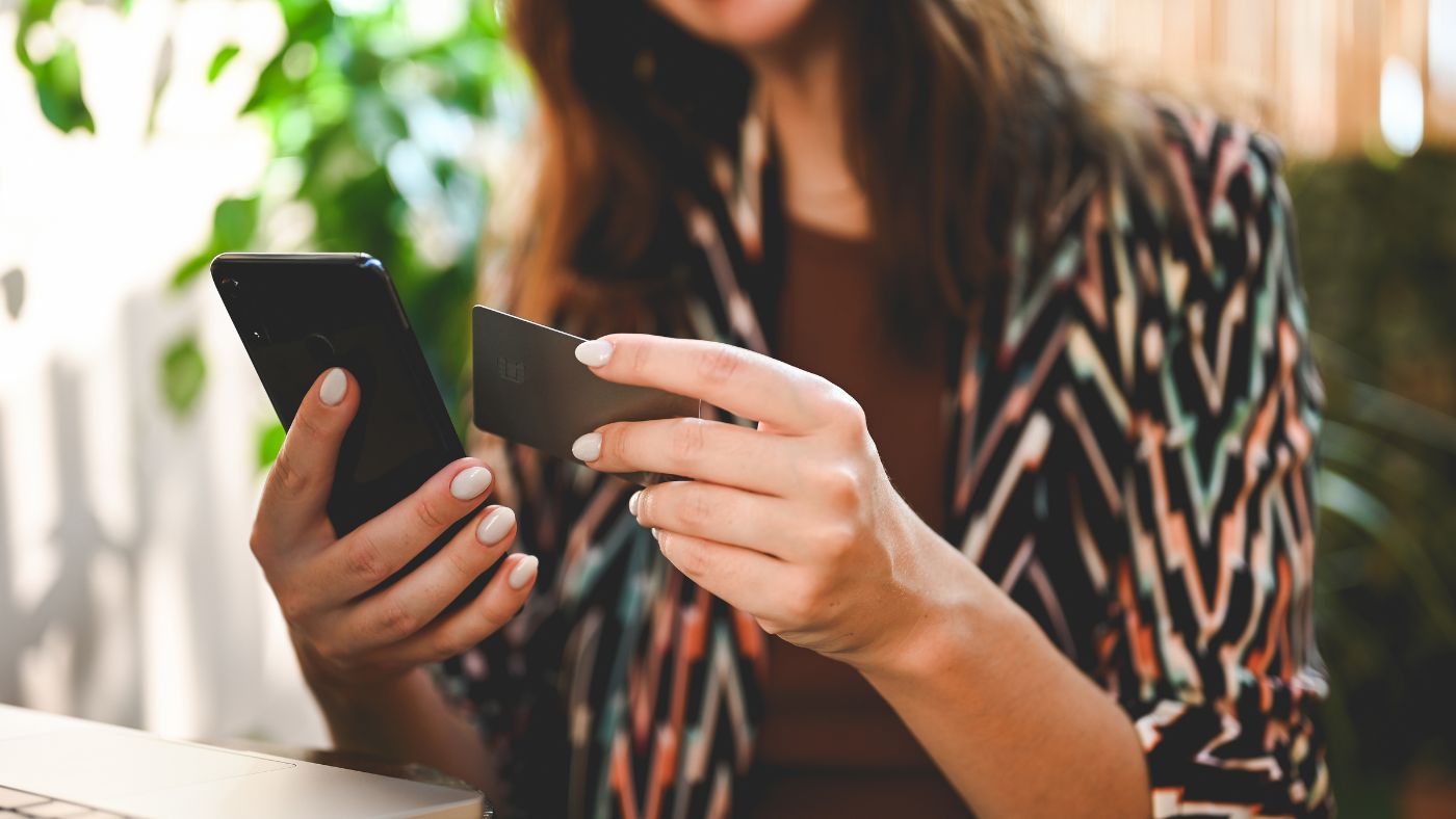 close up of brunette lady tapping an NFC business card on a mobile phone