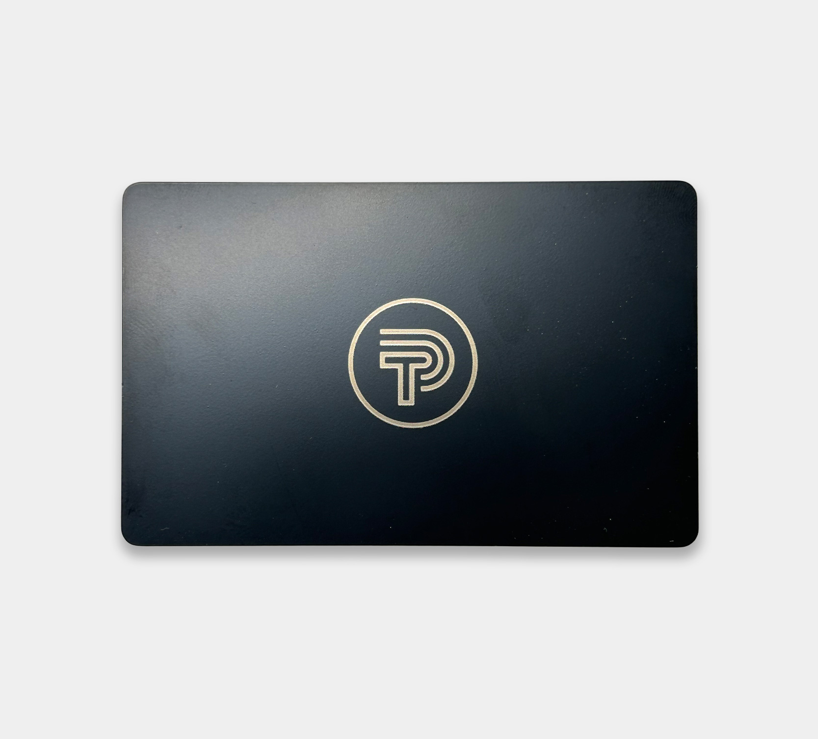 Image showing front of black metal NFC business card with Tap Ping logo engraved in gold