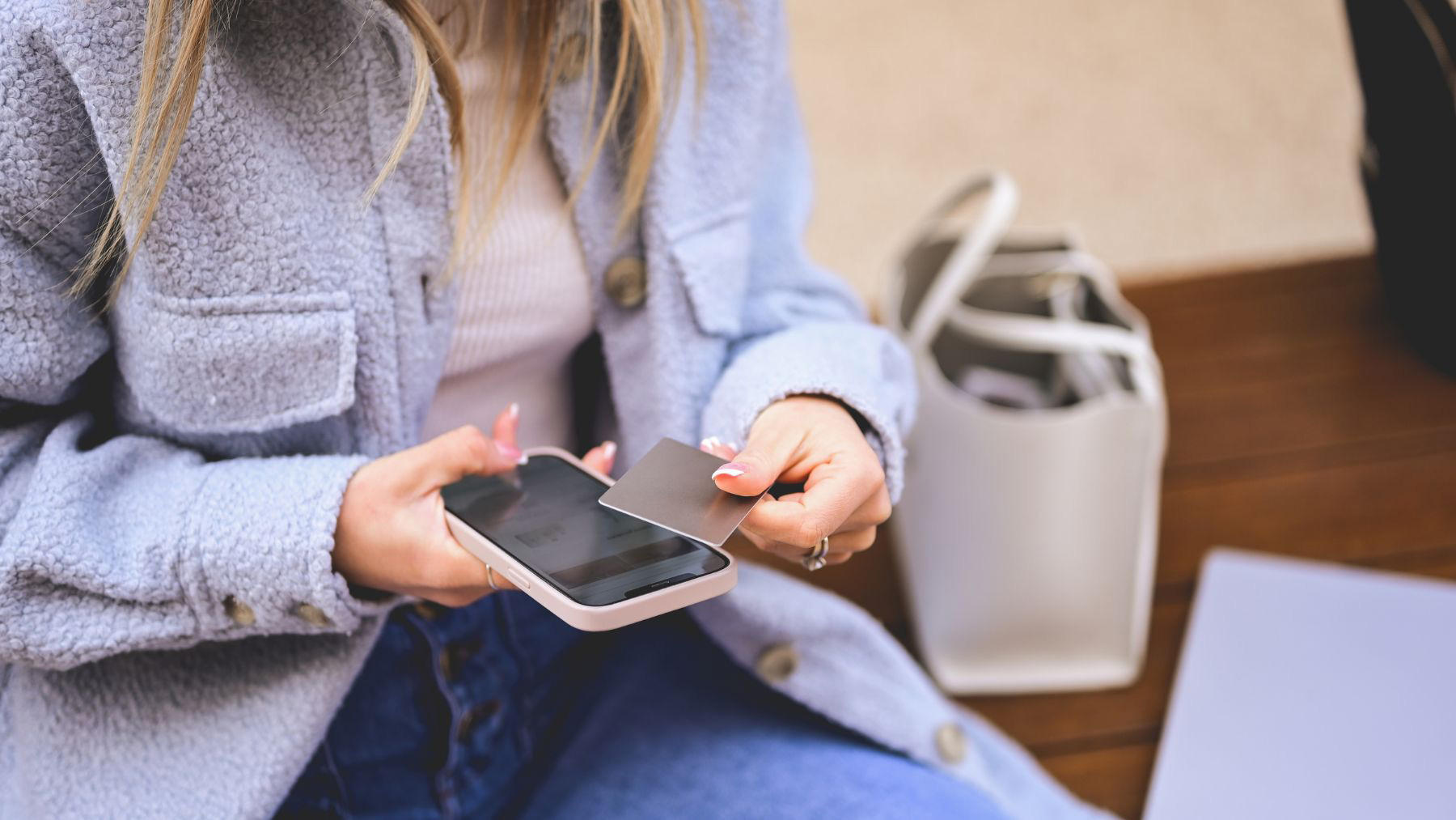Image showing a photo of a Lady in purple top an jeans tapping NFC business card on to her phones